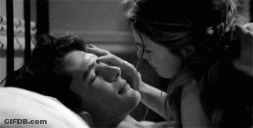 Woman Touching Man's Forehead In Bed GIF