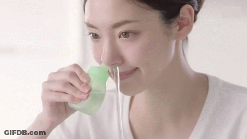 Woman Using Green Container To Clean Nose GIF