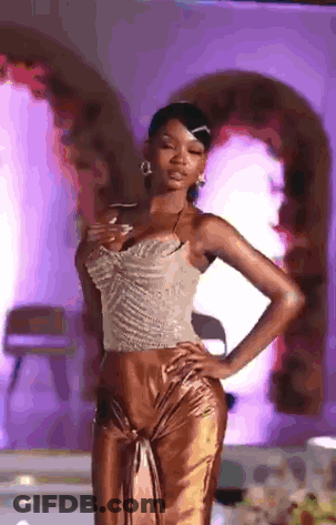 Woman Walking Down Runway Hands On Hips Purple Background GIF