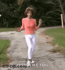 Woman Walking Down Sidewalk With Arms Outstretched GIF