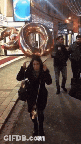 Woman Walking Down Street Holding Balloon Saying Dit GIF