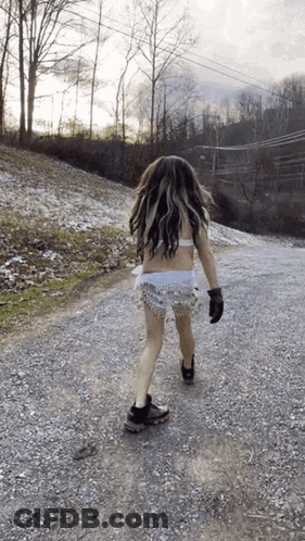 Woman Walking Gravel Road In Bikini Top And Shorts GIF