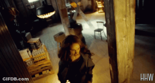 Woman Walking In Dark Room With Letters HW GIF