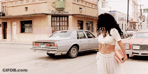 Woman Walking In Front Of Cafe Con Libros GIF