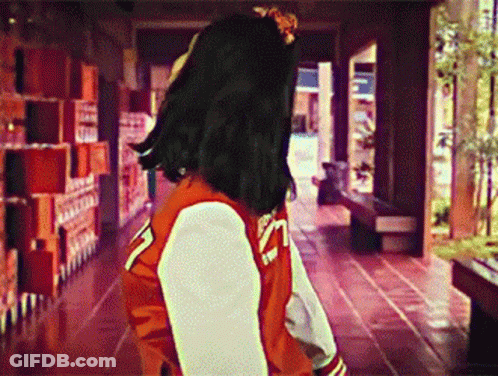 Woman Walking In Red And White Varsity Jacket GIF