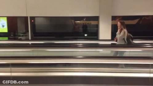 Woman Walking On Escalator Past Qantas Sign GIF
