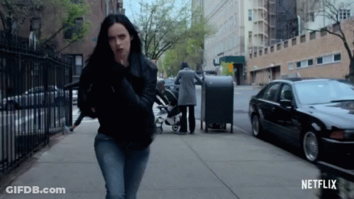 Woman Walking On Sidewalk With Netflix Logo GIF