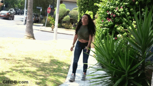 Woman Walking Past Stop Sign GIF