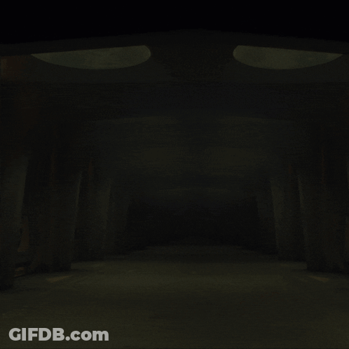Woman Walking Through Dark Hallway With Spotlights GIF