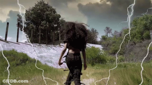 Woman Walking Through Lightning Field GIF