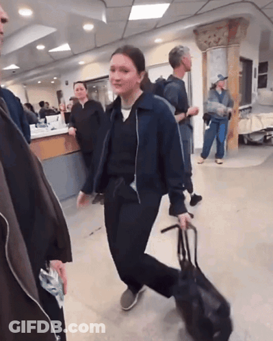 Woman Walking With Bag In Hospital Lobby GIF