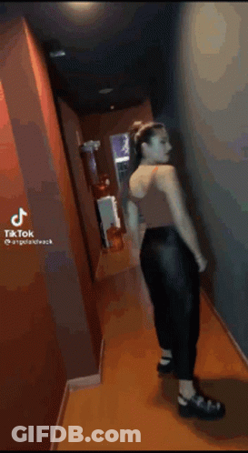 Woman Walking With Windblown Hair And Black Pants GIF