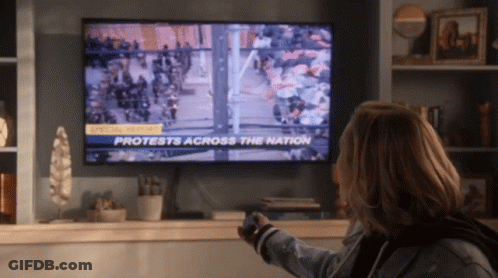 Woman Watching Protests On TV GIF