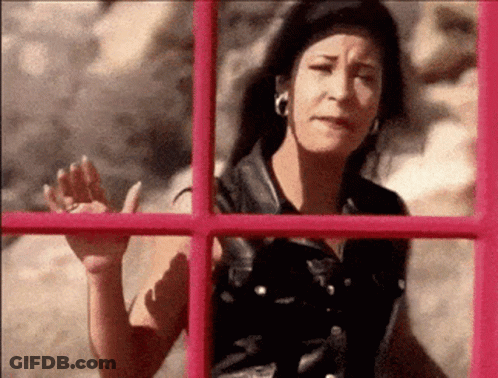 Woman Waving In Front Of Pink Phone Booth GIF