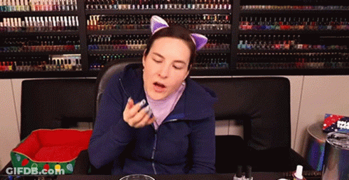 Woman Wearing Cat Ears In Front Of Nail Polish Wall GIF