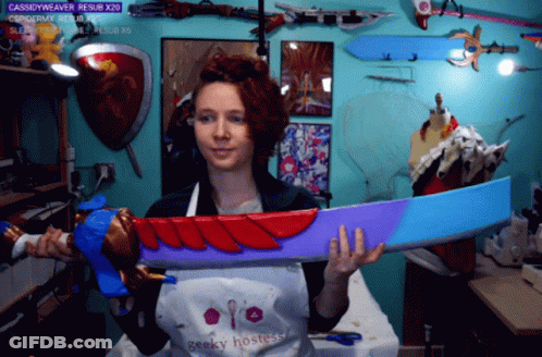 Woman Wearing Geeky Hostess Apron Holding Large Sword GIF