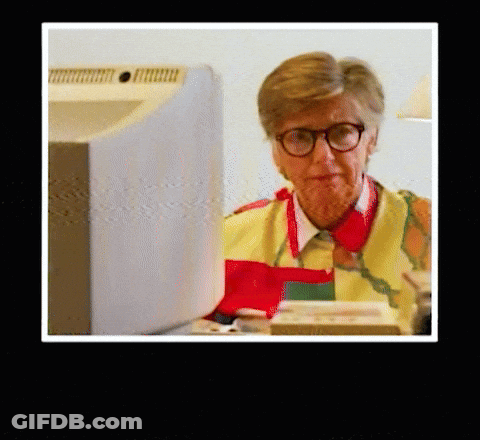 Woman Wearing Glasses And Apron At Computer GIF