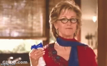 Woman Wearing Glasses And Scarf Holding Something GIF