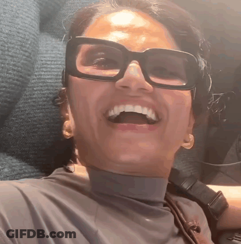 Woman Wearing Glasses And Turtleneck Smiling GIF