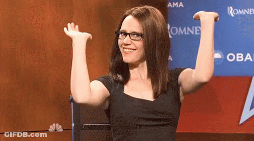 Woman Wearing Glasses Sitting In Front Of Oma Sign GIF