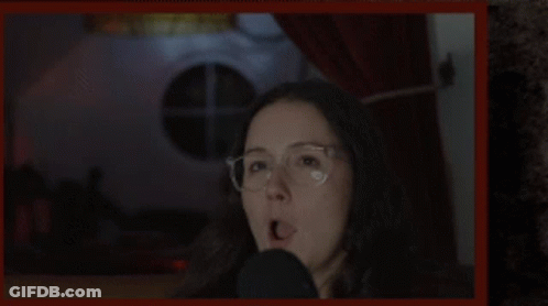 Woman Wearing Glasses Talking Into Microphone GIF