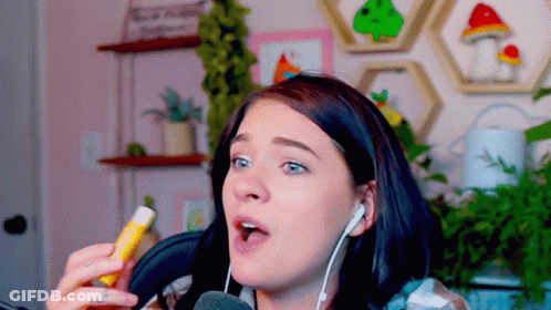 Woman Wearing Headphones Holding Lip Balm GIF