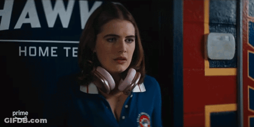 Woman Wearing Headphones In Front Of Awks Sign GIF
