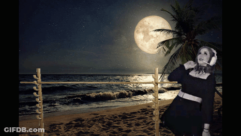 Woman Wearing Headphones On Beach At Night GIF