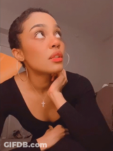 Woman Wearing Hoop Earrings And Cross Necklace Looking Up GIF