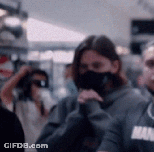Woman Wearing Mask And Man In Hoodie GIF
