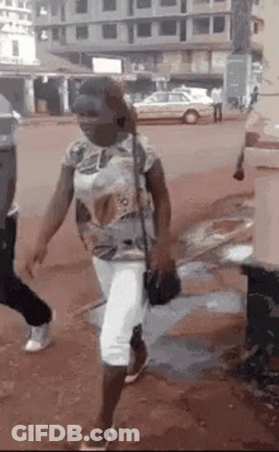 Woman Wearing Mask Walking Down Street With Purse GIF