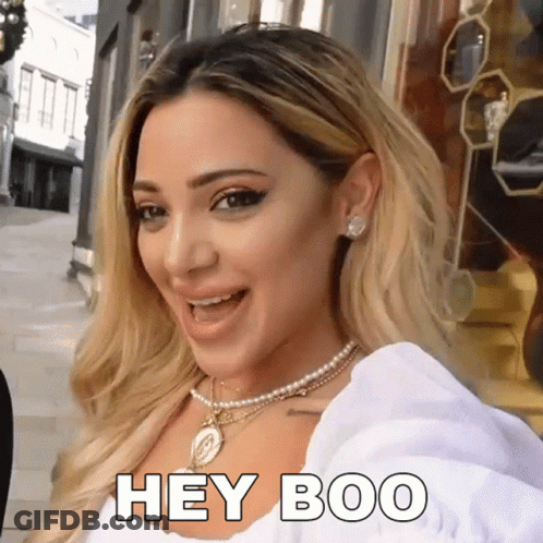 Woman Wearing Pearl Necklace And Earrings Says Hey Boo GIF