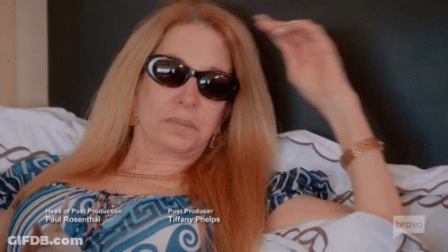 Woman Wearing Sunglasses Lying On Bed GIF