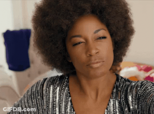 Woman With Afro In Sequined Top Looking At Camera GIF