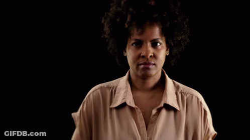 Woman With Afro In Tan Shirt GIF
