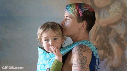 Woman With Arm Tattoo Carrying Child GIF
