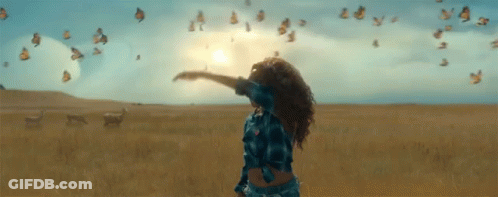 Woman With Arms Outstretched Surrounded By Butterflies GIF