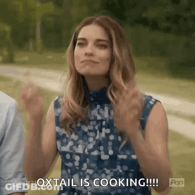 Woman With Arms Up Saying Oxtail Is Cooking GIF
