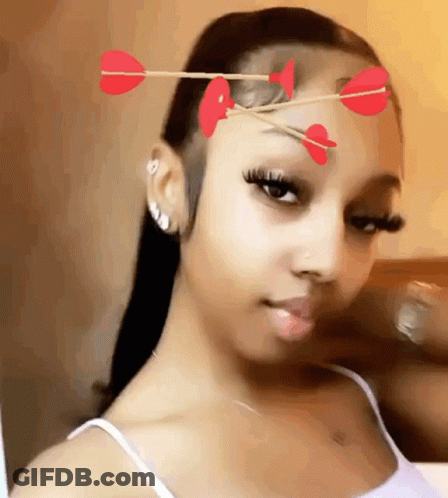 Woman With Arrows In Hair And Hearts Taking Selfie GIF