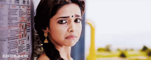 Woman With Bindi Leaning Against Wall With Newspaper GIF