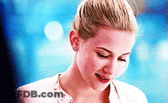 Woman With Blonde Bun Smiling Looking Down GIF