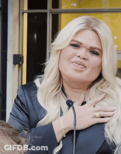 Woman With Blonde Hair Holding Chest GIF