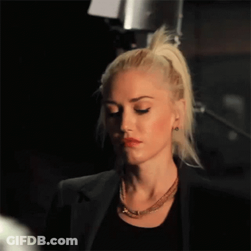 Woman With Blonde Hair In Black Jacket And Necklace GIF