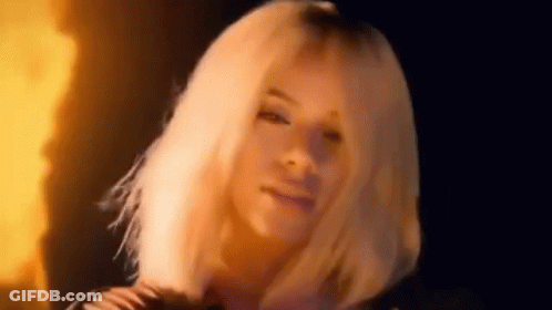 Woman With Blonde Hair In Front Of Fire GIF