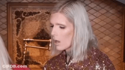Woman With Blonde Hair In Front Of Fireplace GIF