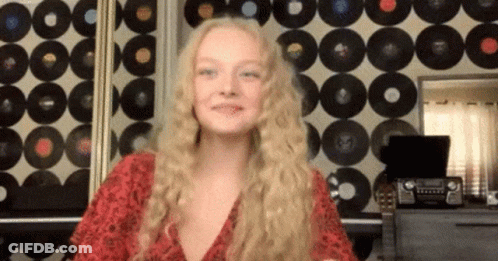 Woman With Blonde Hair In Front Of Record Wall GIF