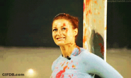Woman With Blood On Face Smiling Next To Pole GIF