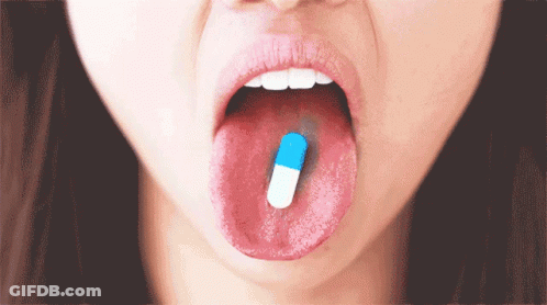 Woman With Blue And White Capsule In Mouth GIF