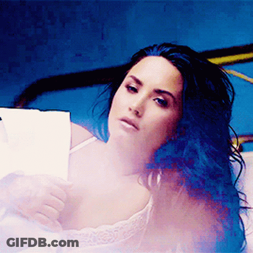 Woman With Blue Hair Laying On Bed GIF