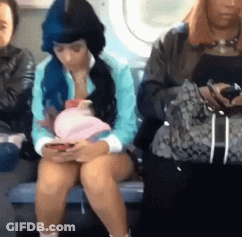 Woman With Blue Hair Sitting On Bus Looking At Phone GIF
